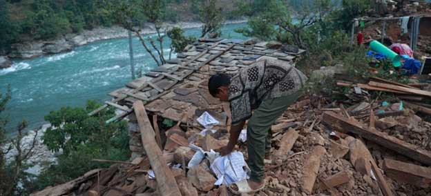 A boy sifts through the rubble of his earthquake-hit home in Rukum (West), Nepal, in November 2023. Credit: UNICEF/ Laxmi Prasad Ngakhus