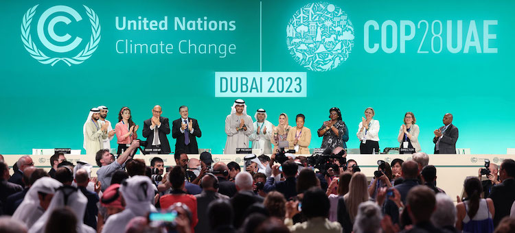 Photo: COP28 President Sultan Al Jaber (centre), UN climate chief Simon Stiell (fourth from left) and other participants onstage during the Closing Plenary of the UN Climate Change Conference, COP28, at Expo City in Dubai, United Arab Emirates. COP28 | Christopher Pike