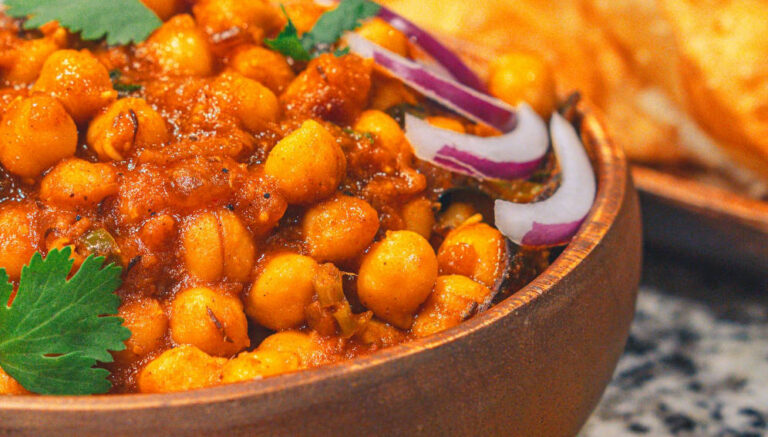 Bowl of stewed chickpeas with onion. Chickpea curry has a surprisingly large impact on biodiversity says Ranjit Devraj. Copyright: Pexels (Free to use).