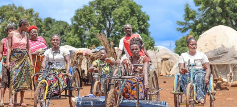 © IOM/Elijah Elaigwu Women on tricycles make their way through a camp for displaced people in Nigeria.