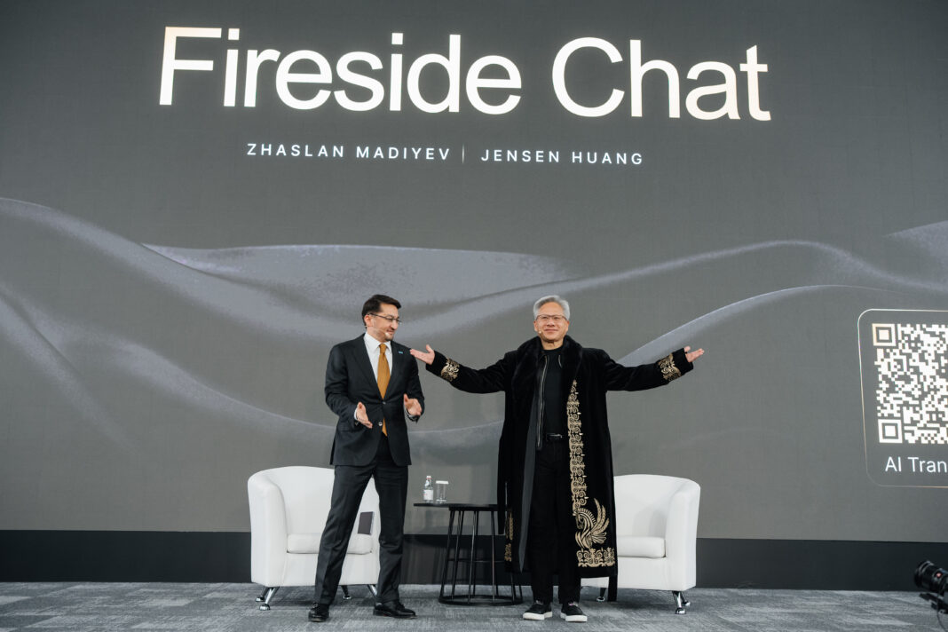 NVIDIA CEO Jensen Huang (right) wears a traditional Kazakh chapan presented to him by Zhaslan Madiyev, Kazakhstan’s deputy prime minister and minister of artificial intelligence and digital development, following their fireside chat at alem.ai in Astana on October 23, 2026. | Photo: Astana Hub.